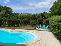 a swimming pool with two chairs and a table and a swing at Océan à 10 mn, maison avec piscine, bar et babyfoot in Saint-Paul-en-Born