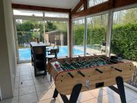 a wooden foosball table in a room with a pool at Océan à 10 mn, maison avec piscine, bar et babyfoot in Saint-Paul-en-Born