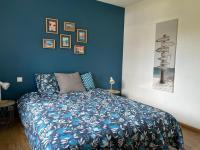 a blue bedroom with a bed with a blue wall at Océan à 10 mn, maison avec piscine, bar et babyfoot in Saint-Paul-en-Born