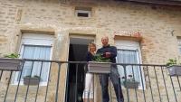 a man and a woman standing on a balcony at Le cottage du village in Seigny
