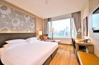 a hotel room with a large bed and a desk at Eastin Grand Hotel Sathorn in Bangkok