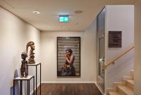 a hallway with a painting of a woman talking on a phone at AMERON Hamburg Hotel Speicherstadt in Hamburg