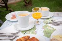 een tafel met twee kopjes koffie en borden eten bij Hôtel au Heimbach in Lembach