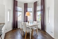 a dining room with a table and chairs and windows at Dresden Neustadt Apartments in Dresden