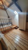 an attic room with a bed and a wooden floor at Chateau Mano in Mairé-lʼEveseault