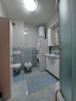 a bathroom with a sink and a washing machine in it at Apartman Sany in Bihać