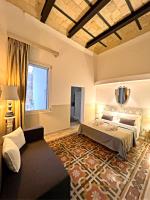 a bedroom with a bed and a couch and a window at Eccelsoleccese Boutique B&amp;B - steps from the Historic Center in Lecce
