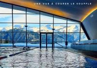 a swimming pool with a view of snow covered mountains at Ecrin Blanc Resort Courchevel in Courchevel