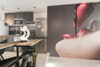 a kitchen with a painting of a woman on a wall at Le Jardin secret in Pontoise