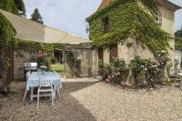 a table and chairs in front of a building at Manoir du Bois Mignon in Le Fleix