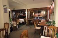 Un comedor con mesas y sillas en un restaurante. en HB Express Hotel, en Tlaxcala de Xicohténcatl