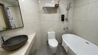 a bathroom with a sink and a toilet and a tub at 海的墾丁旅店 Ocean KT Inn in Kenting