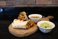 a burrito and a bowl of guacamole and a bowl of salsa at Treppan Hotel & Suites By Fakhruddin in Dubai