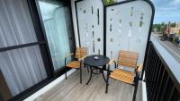 a balcony with two chairs and a table on it at 海的墾丁旅店 Ocean KT Inn in Kenting