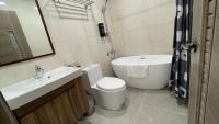 a bathroom with a sink and a toilet and a tub at 海的墾丁旅店 Ocean KT Inn in Kenting