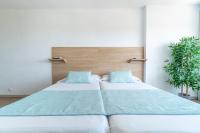 Łóżko lub łóżka w pokoju w obiekcie Apartaments La Perla Negra
