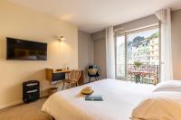 a hotel room with a bed and a balcony at Hôtel De La Vallée in Dinard