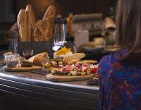 a woman standing in front of a table with pizzas at Campanile Nancy Centre - Gare in Nancy