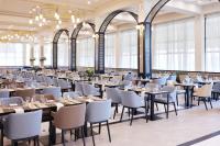 Un comedor con mesas y sillas y ventanas. en Azul Beach Resort Montenegro by Karisma - All Inclusive, en Ulcinj