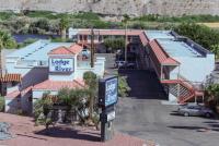 Un cartel delante de una casa con garaje. en lodge on the river, en Bullhead City