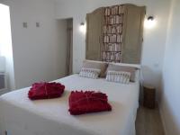 a large white bed with two red pillows on it at Gîte Le Bernard, 6 pièces, 10 personnes - FR-1-426-164 in Le Bernard