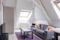 a living room with a couch and a table at gîte de l&#39;artiste Segré ✰ T2 confort ✰ centre ✰ 2 lits in Segré