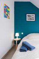 a bedroom with a blue wall and a bed and a table at gîte de l&#39;artiste Segré ✰ T2 confort ✰ centre ✰ 2 lits in Segré