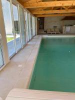 a swimming pool in a house with a wooden ceiling at LE VIEUX MOULIN in Bouhet