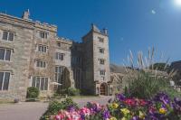 un viejo edificio de piedra con flores delante en Boringdon Hall Hotel and Spa, en Plymouth