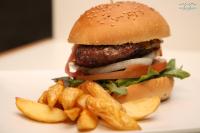 a hamburger and french fries on a white plate at Hostal La Janda in Vejer de la Frontera