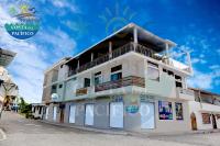 un edificio blanco al costado de una calle en Hostal Costa del Pacifico, en Puerto Ayora