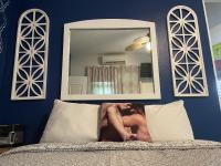 a man laying on a bed in front of a mirror at Lower Price, More Style, Discount Studio In San Juan,Pr, Beach, Free Bikes in San Juan