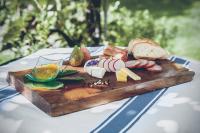 uma tábua de corte de madeira com comida numa mesa em Hôtel de Chailly em Montreux