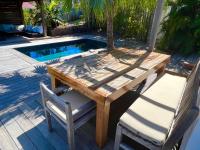 a wooden table and chairs next to a swimming pool at Nice 2 bed-rooms villa at Saint Barth in Saint Barthelemy