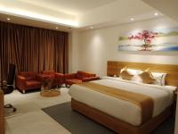 Un dormitorio con una cama grande y una sala de estar. en Hotel X Rajshahi, en Rājshāhi