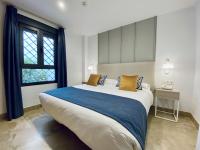 a bedroom with a large bed and a window at Hotel Apartamentos Marina Luz in Chipiona