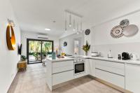 Una cocina con gabinetes blancos y una ventana grande. en Dreamy 2 bed apartment by the sea, en Pafos