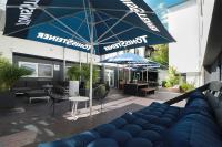 a patio with a blue couch and an umbrella at Hotel Haverkamp in Bremerhaven