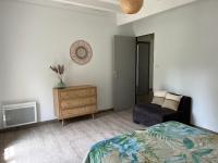 a bedroom with a bed and a dresser and a chair at T3 Linxe océan et nature in Linxe
