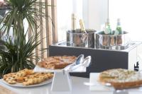 a table with two plates of pastries and bottles of wine at Midenza Seaside & Nature Retreat in Capo Vaticano