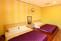 two beds in a room with yellow walls at Family Pottery in Hengchun South Gate