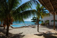 DikoniにあるUroa Zanzibar Vera Beach Hotel by Moonshineのプール、ヤシの木、海を望むリゾート