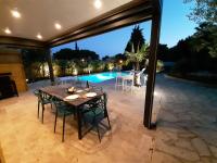 a patio with a table and chairs and a pool at VILLA RASOA chambre LIBELLULE in Cap d&#39;Agde