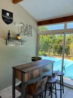 a room with a bar with two chairs and a window at Océan à 10 mn, maison avec piscine, bar et babyfoot in Saint-Paul-en-Born