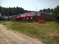 un edificio con sillas rojas y sombrillas rojas en Schoolhouse Inn, en Killaloe Station
