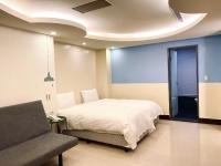 a bedroom with a bed and a couch in it at Spa Spring Resort in Taipei