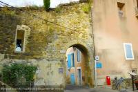 an old stone building with a blue door and an archway at Les demeures du Ventoux in Aubignan