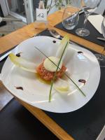 un plato blanco con algo de comida en una mesa en Logis Hôtel Le Cygne, en Le Bugue