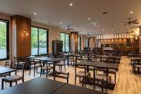 Un comedor con mesas y sillas y ventanas. en KAMENOI HOTEL Okunikko, en Nikko