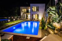 a swimming pool in the backyard of a house at night at Villa Magic look in Donji Proložac